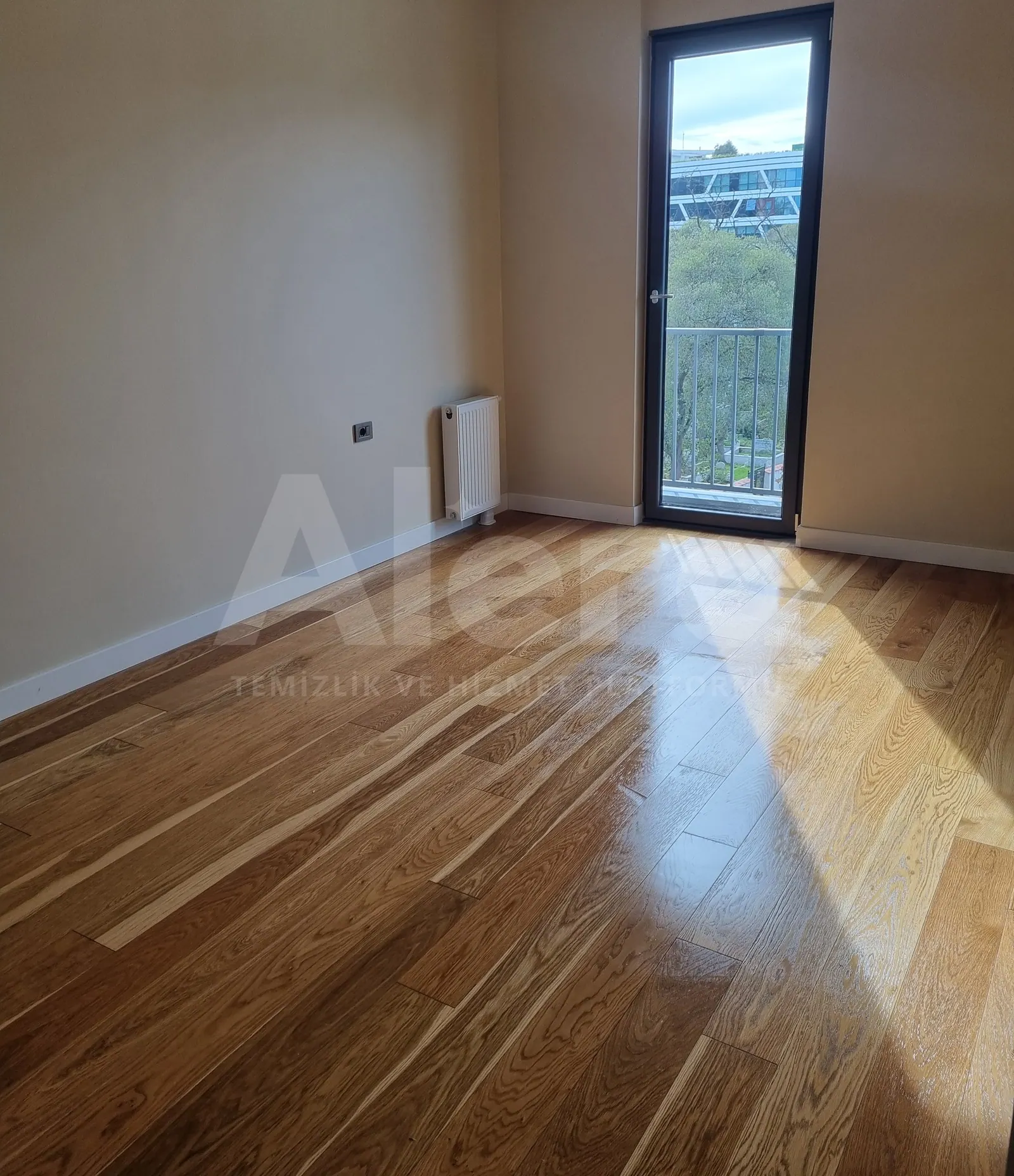 Yeni teslim dairede balkon kapılı oda ve parlak parke zemin