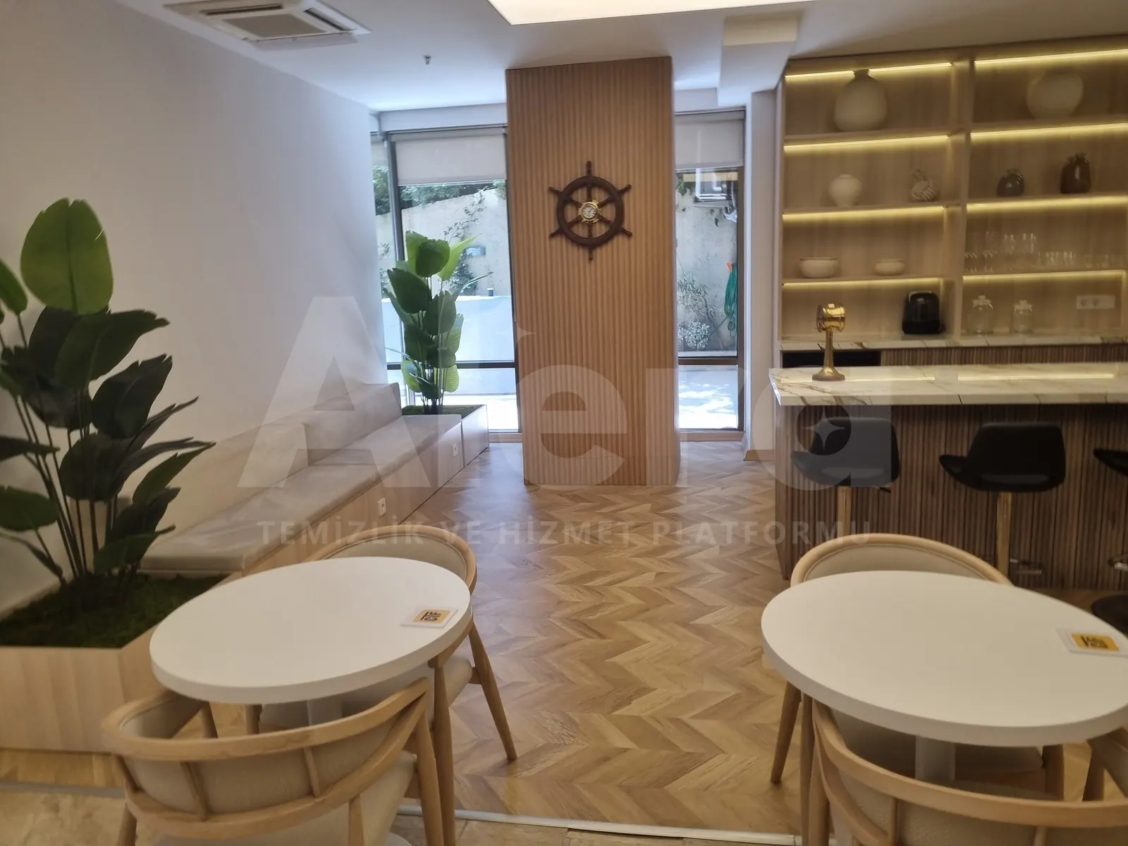 Ofisin kafeterya köşesinde bar, tezgâh, masalar ve parke zemin